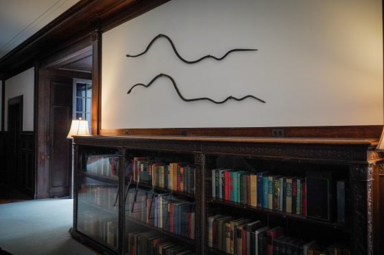 Two black iron snakes hanging on a wall in the Peirce du Pont House at Longwood Gardens.